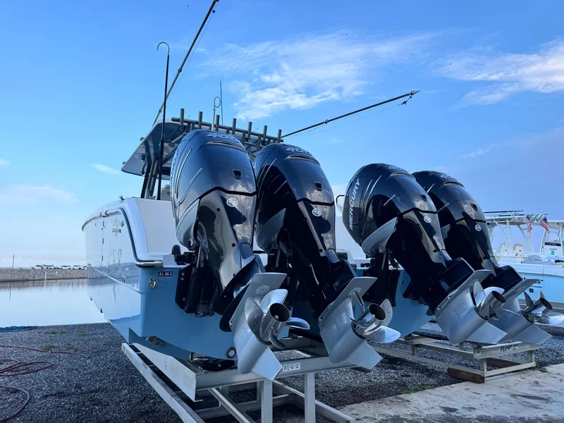 Slide: The Image of 2022 Invincible 40 Catamaran with four powerful outboard engines, docked by the water. - 4