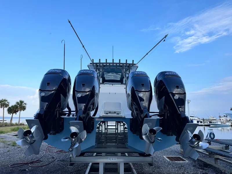 Slide: The Image of 2022 Invincible 40 Catamaran with four powerful outboard engines, docked by the shore. - 5