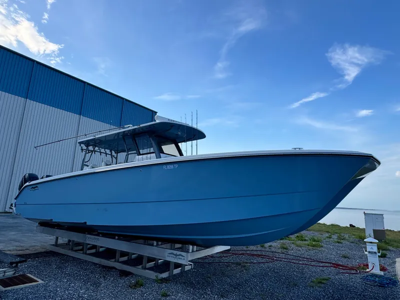 Slide: The Image of 2022 Invincible 40 Catamaran in blue, docked near a warehouse under a clear sky. - 8