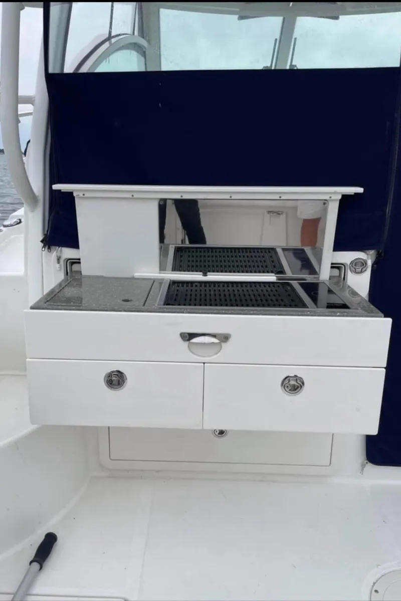Slide: The Image of Boston Whaler 315 Conquest 2013 boat interior with storage drawers and countertop. - 10