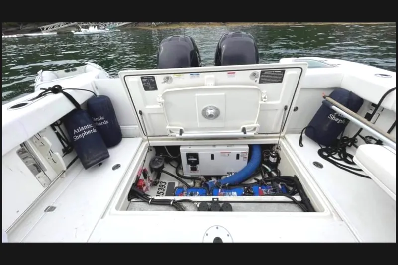 Slide: The Image of 2013 Boston Whaler 315 Conquest engine compartment with open hatch, showcasing marine equipment. - 11