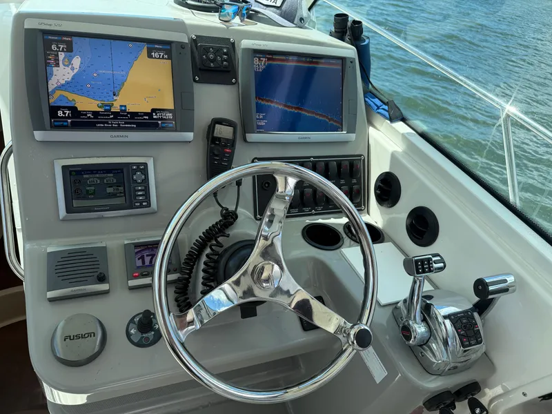 Slide: The Image of Control panel of a 2013 Boston Whaler 315 Conquest with navigation screens and steering wheel. - 3