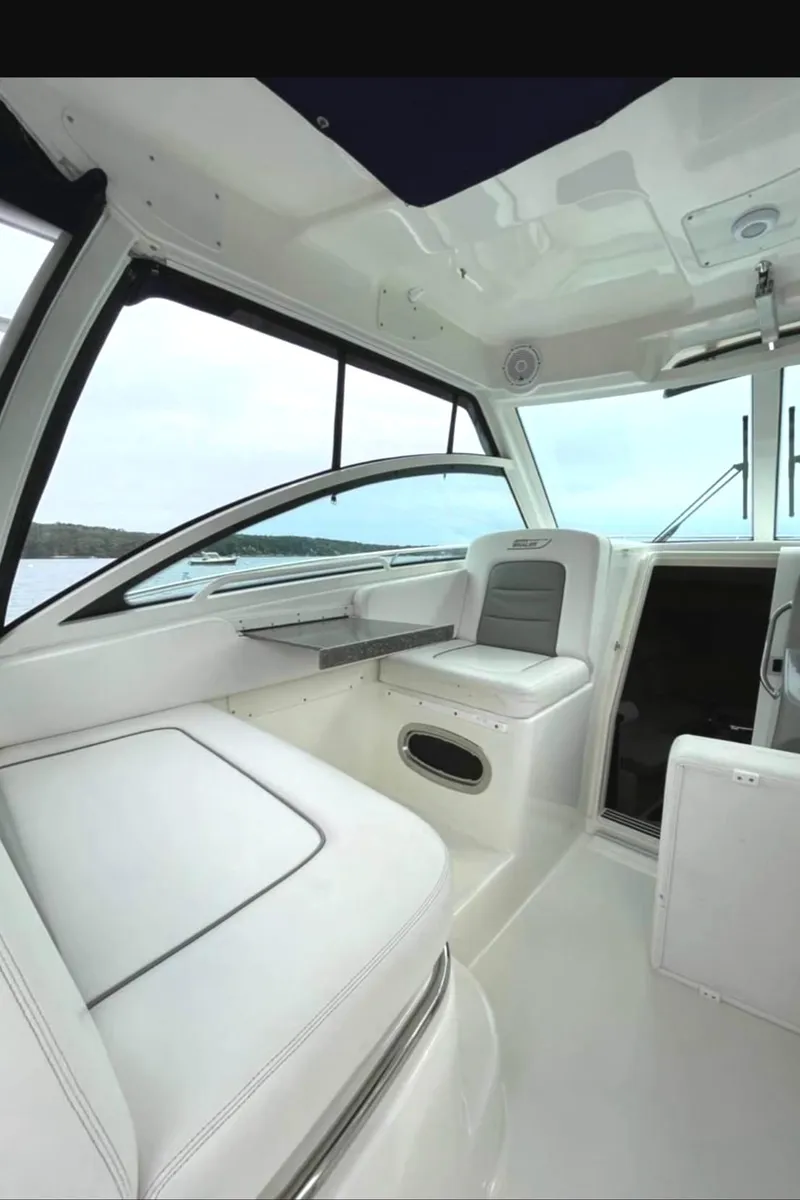Slide: The Image of 2013 Boston Whaler 315 Conquest interior with seating and table, showcasing modern design. - 7