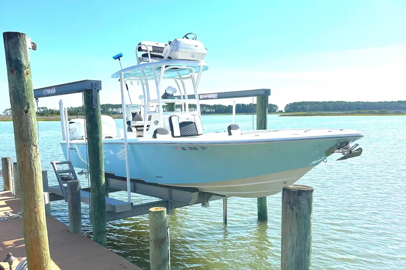 Slide: The Image of 2021 Tidewater 2700 Carolina Bay boat on lift by dock, sunny day. - 0
