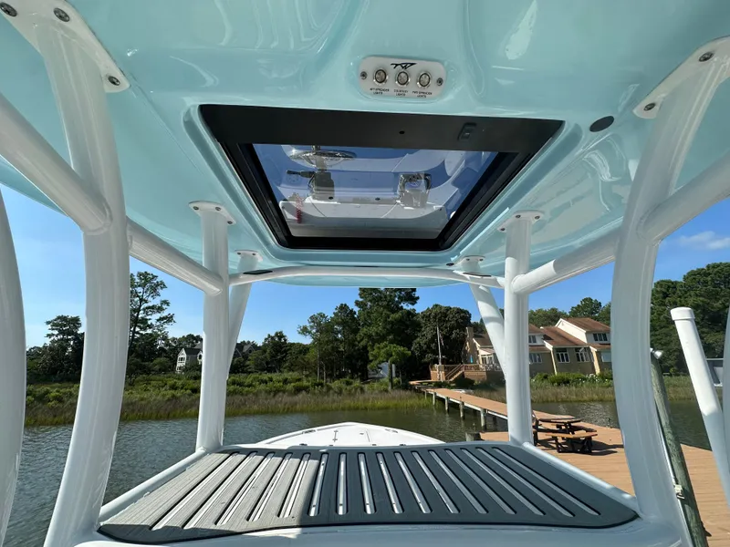 Slide: The Image of 2021 Tidewater 2700 Carolina Bay boat with T-top and scenic waterfront view. - 11