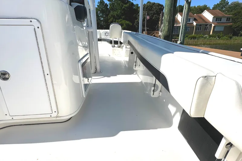 Slide: The Image of 2021 Tidewater 2700 Carolina Bay boat interior with white seating and storage compartments. - 14