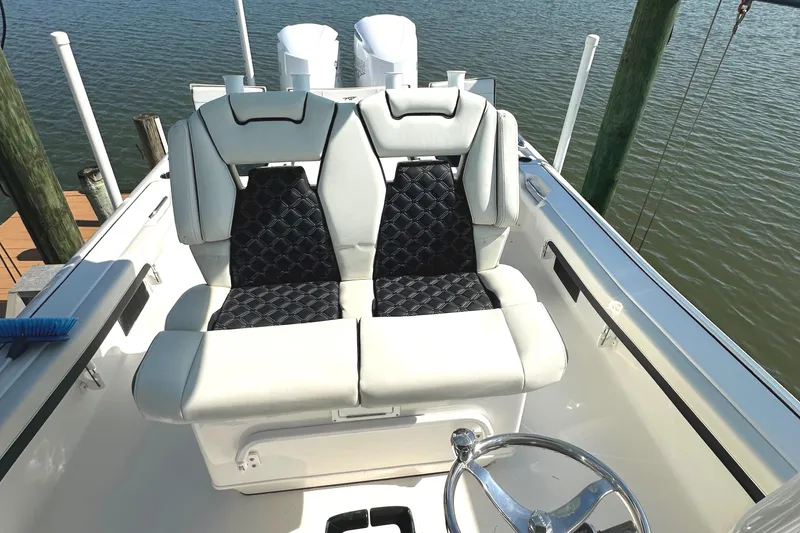 Slide: The Image of 2021 Tidewater 2700 Carolina Bay boat with dual cushioned seats and steering wheel. - 17