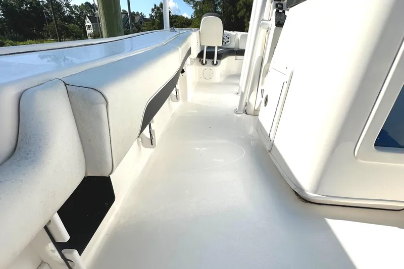 Slide: The Image of 2021 Tidewater 2700 Carolina Bay boat interior with white seating and clean deck. - 18