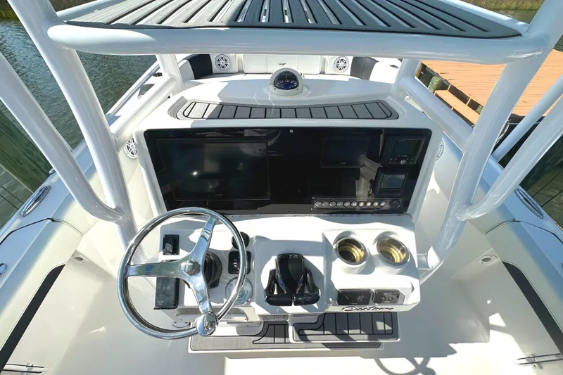 Slide: The Image of 2021 Tidewater 2700 Carolina Bay boat console with steering wheel and navigation controls. - 6