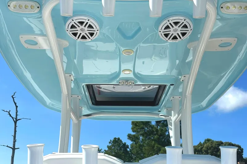 Slide: The Image of 2021 Tidewater 2700 Carolina Bay boat, featuring speakers and rod holders under a blue canopy. - 7