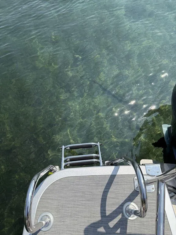 Slide: The Image of Bennington 23 LSBA 2022 boat ladder over clear water. - 18