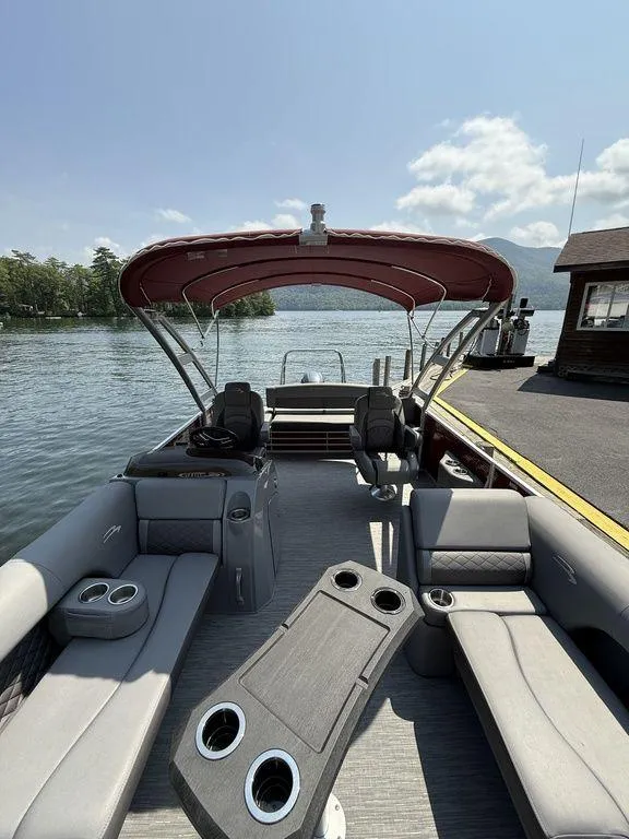 Slide: The Image of 2022 Bennington 23 LSBA pontoon boat with spacious seating and canopy on a sunny day. - 20