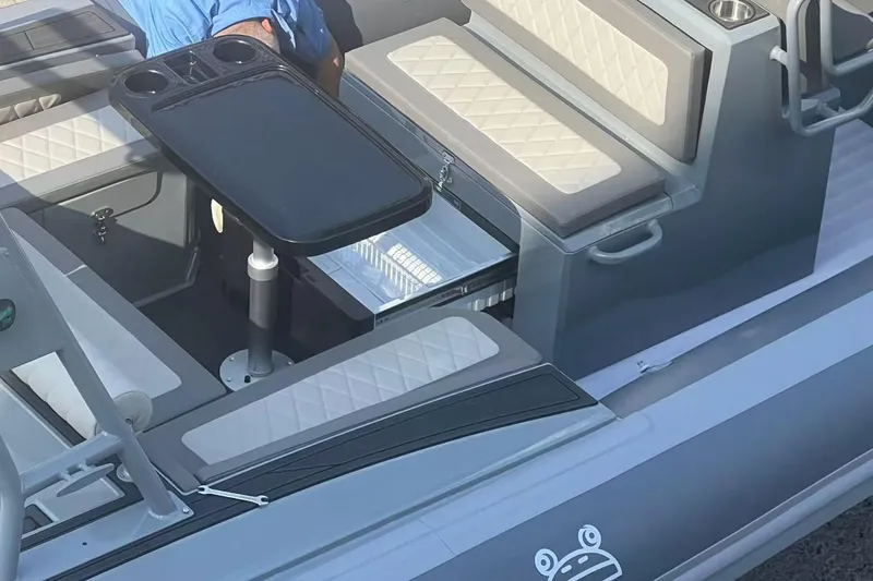 Slide: The Image of Interior of 2025 RIB-IT Ultra Light 26 boat with seating and table setup. - 9
