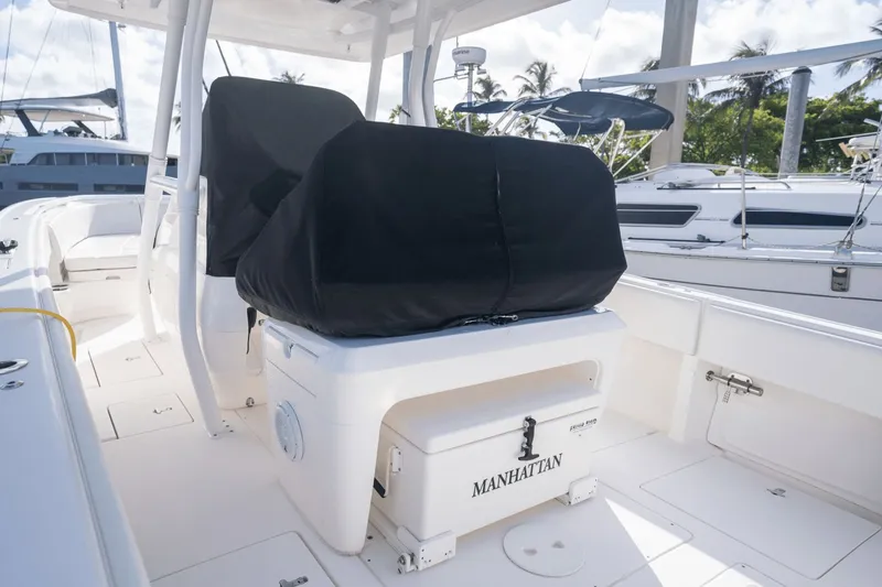 Slide: The Image of 2015 Intrepid 327 CC INFUSED boat interior with covered seats and storage. - 10
