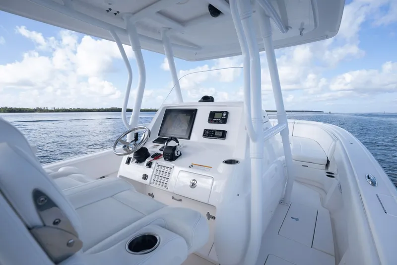 Slide: The Image of 2015 Intrepid 327 CC Infused boat interior with steering console and ocean view. - 14