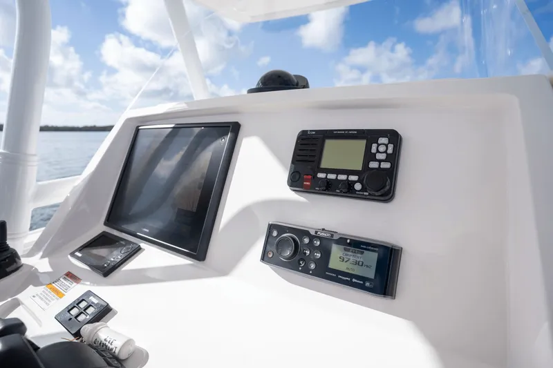 Slide: The Image of 2015 Intrepid 327 CC Infused boat dashboard with navigation and communication equipment. - 16
