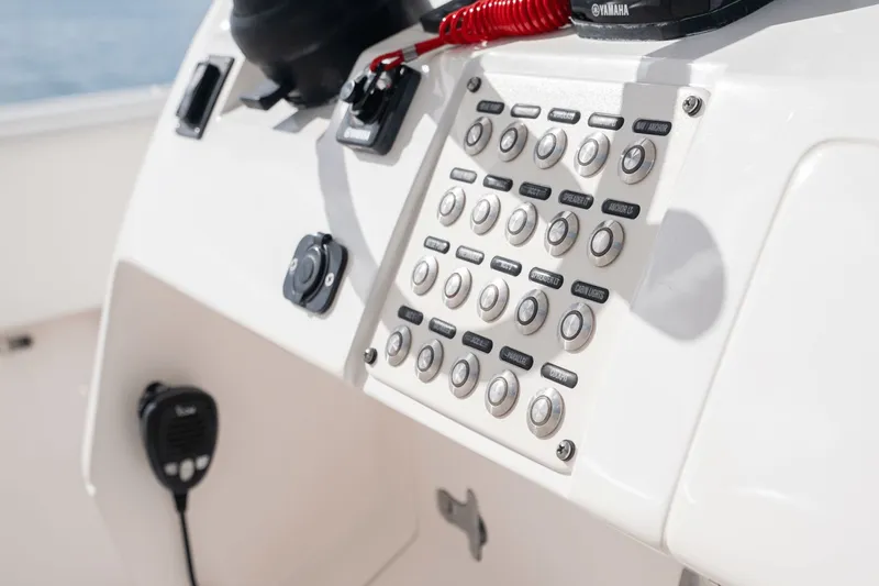 Slide: The Image of Control panel of a 2015 Intrepid 327 CC INFUSED boat with various buttons and switches. - 17
