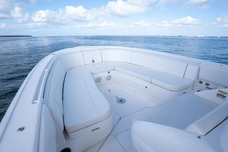 Slide: The Image of 2015 Intrepid 327 CC boat with white seating, ocean view, and blue sky. - 22