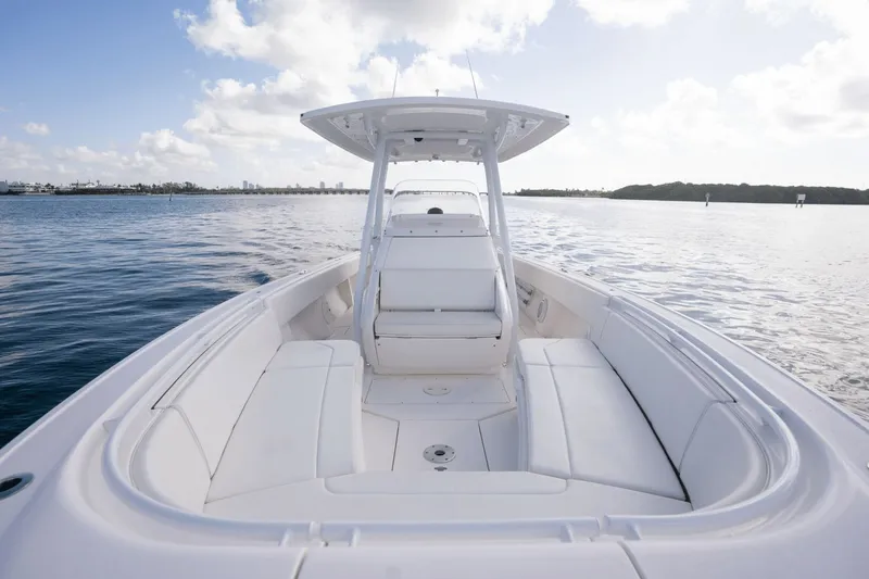 Slide: The Image of 2015 Intrepid 327 CC INFUSED boat on calm water, showcasing spacious seating and sleek design. - 24