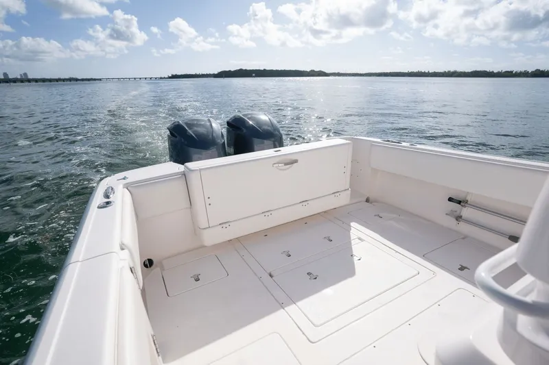 Slide: The Image of 2015 Intrepid 327 CC INFUSED boat on open water, featuring dual engines and spacious deck. - 25