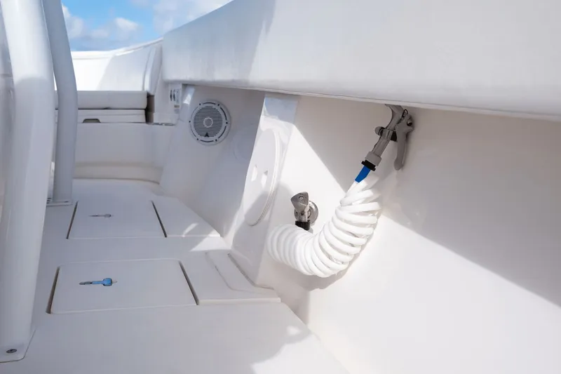 Slide: The Image of 2015 Intrepid 327 CC INFUSED boat deck with coiled hose and speaker. - 29