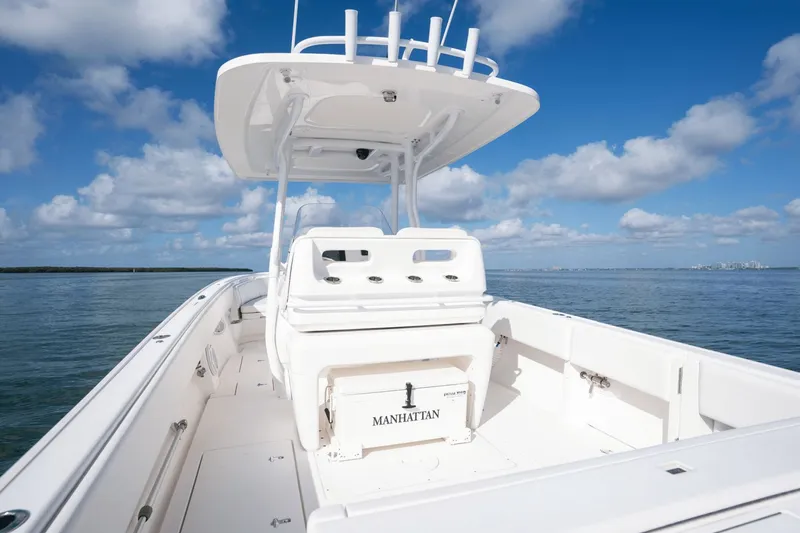 Slide: The Image of 2015 Intrepid 327 CC INFUSED boat on calm water under blue sky. - 30