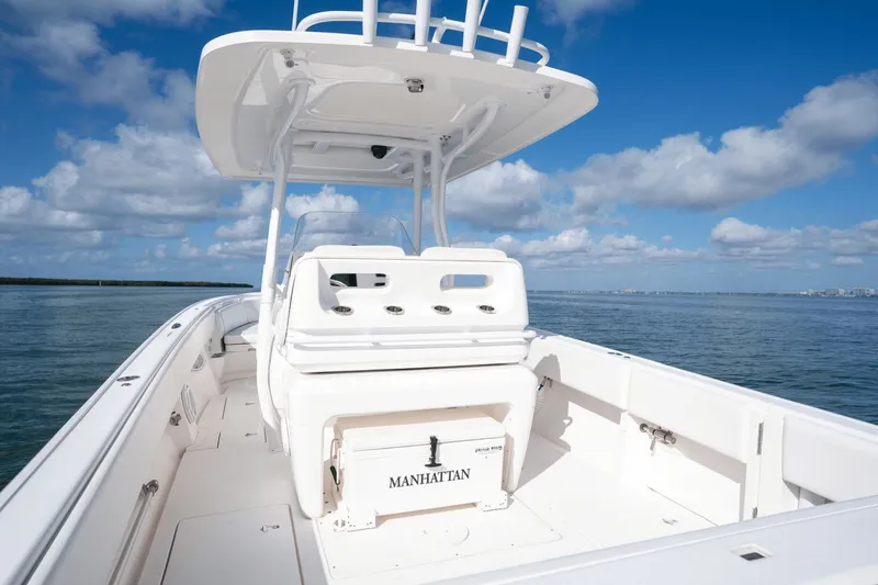 Slide: The Image of 2015 Intrepid 327 CC INFUSED boat on calm water under blue sky. - 31