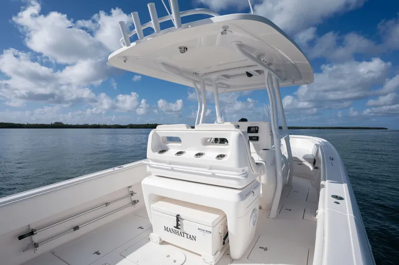 Slide: The Image of 2015 Intrepid 327 CC INFUSED boat on calm water under blue sky. - 32