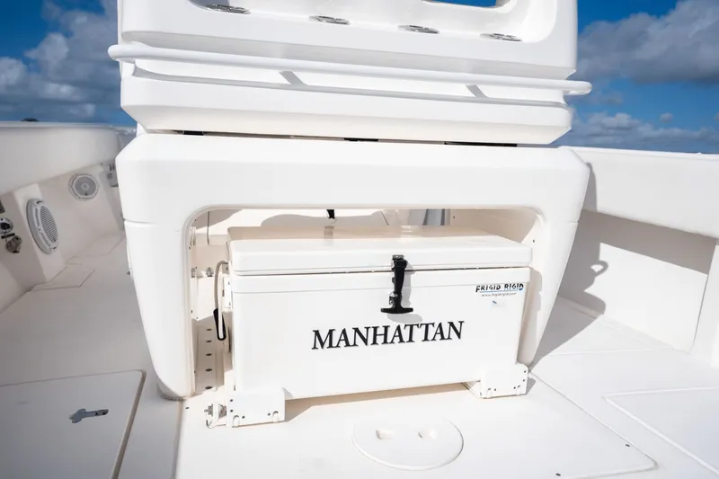 Slide: The Image of 2015 Intrepid 327 CC INFUSED boat with a "MANHATTAN" labeled cooler on deck. - 33