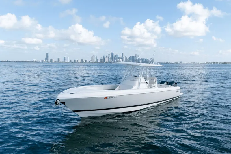 Slide: The Image of 2015 Intrepid 327 CC boat on calm water with city skyline in background. - 4