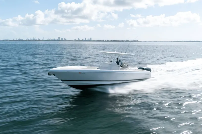 Slide: The Image of 2015 Intrepid 327 CC INFUSED boat cruising on open water under a clear sky. - 5