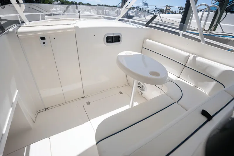 Slide: The Image of 2005 Intrepid 348 WA boat interior with white seating and small table. - 12