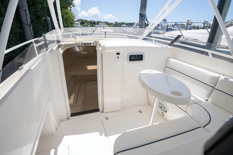Slide: The Image of 2005 Intrepid 348 WA boat interior with seating and table, docked under clear skies. - 13