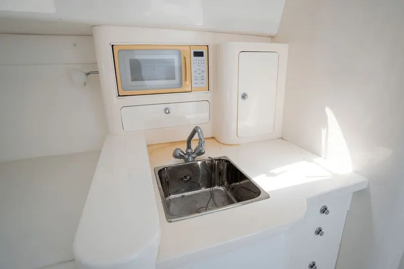Slide: The Image of Compact kitchenette in a 2005 Intrepid 348 WA boat with sink and microwave. - 15