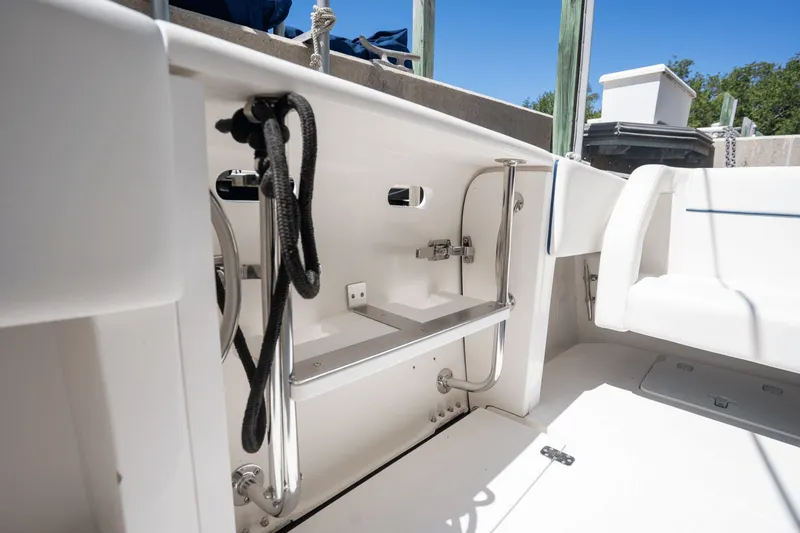 Slide: The Image of 2005 Intrepid 348 WA boat interior with stainless steel fittings and white seating. - 18