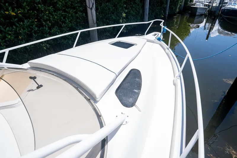 Slide: The Image of 2005 Intrepid 348 WA boat docked, featuring sleek white deck and railing. - 19
