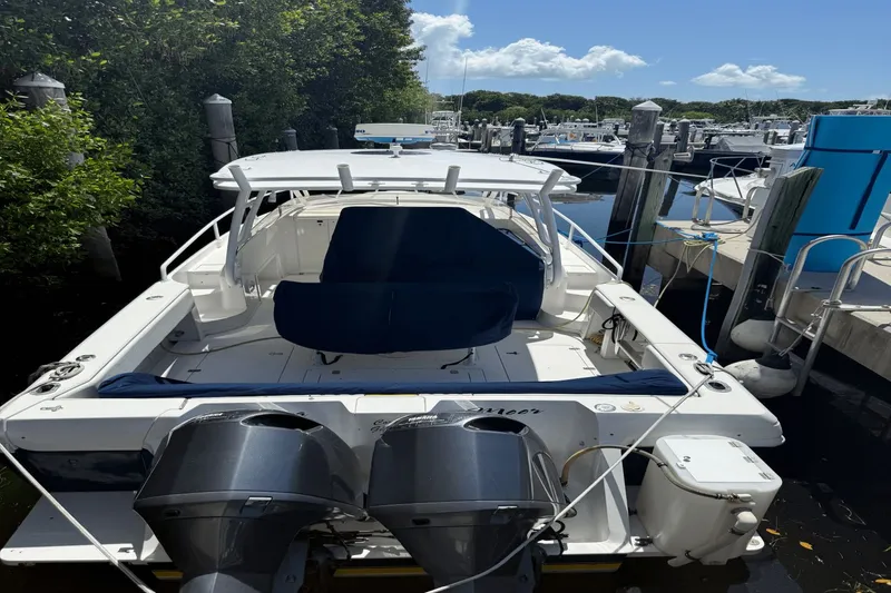 Slide: The Image of 2005 Intrepid 348 WA boat docked, featuring dual outboard motors and spacious seating. - 22