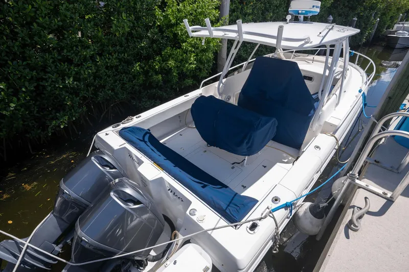 Slide: The Image of 2005 Intrepid 348 WA boat docked, featuring dual outboard engines and blue seating covers. - 4