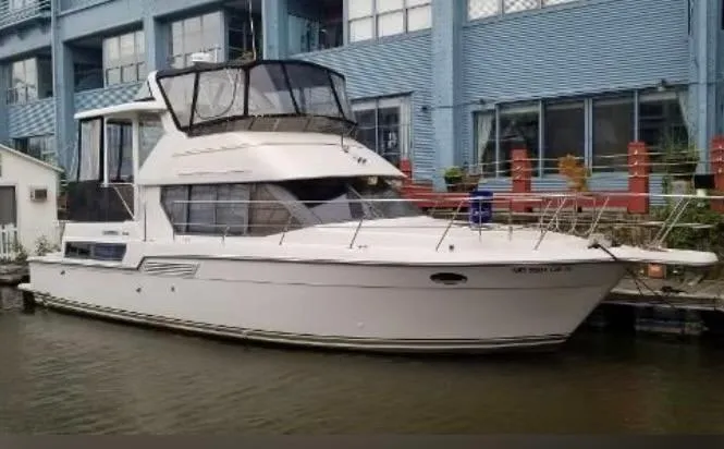 The Image of 1994 Carver 390 Cockpit Motor Yacht docked near a blue building. - 0