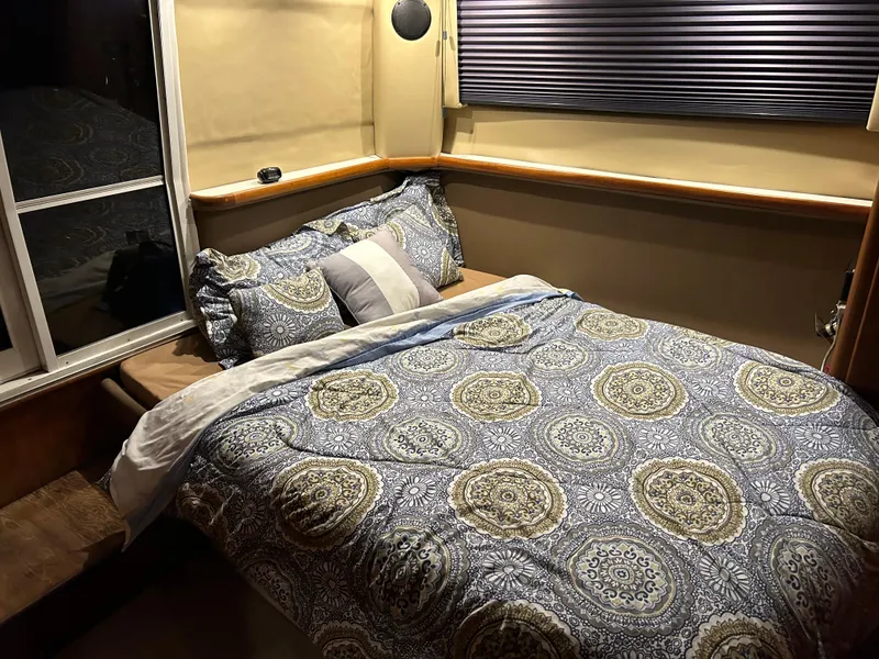 Slide: The Image of Cozy bedroom in 1994 Carver 390 Cockpit Motor Yacht with patterned bedding and soft lighting. - 5
