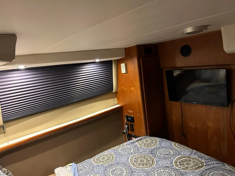 Slide: The Image of Interior of 1994 Carver 390 Cockpit Motor Yacht with bed, TV, and window blinds. - 7