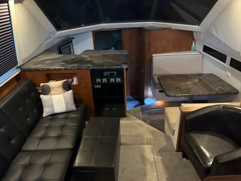 Slide: The Image of Interior of 1994 Carver 390 Cockpit Motor Yacht with modern seating and dining area. - 2