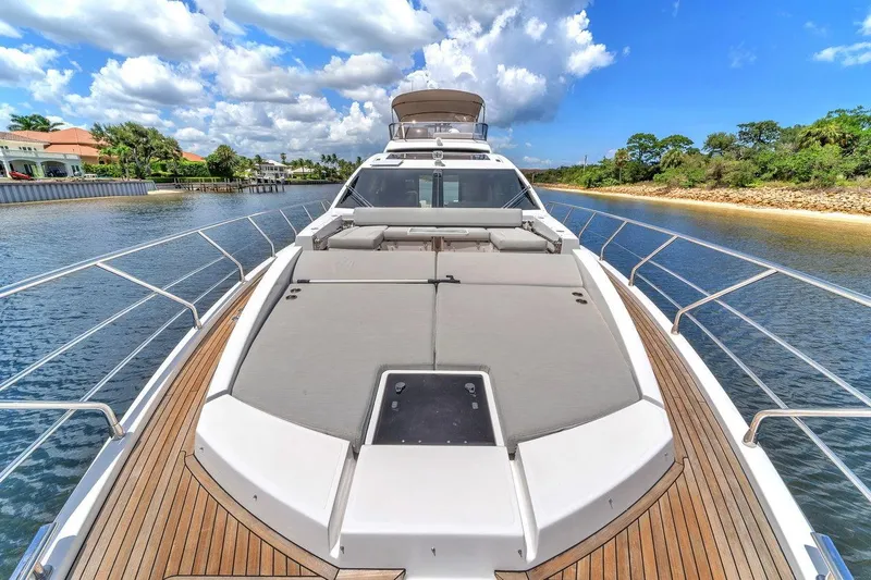 Slide: The Image of Luxurious 2020 Azimut S7 FLY yacht cruising on a scenic waterway under a blue sky. - 14