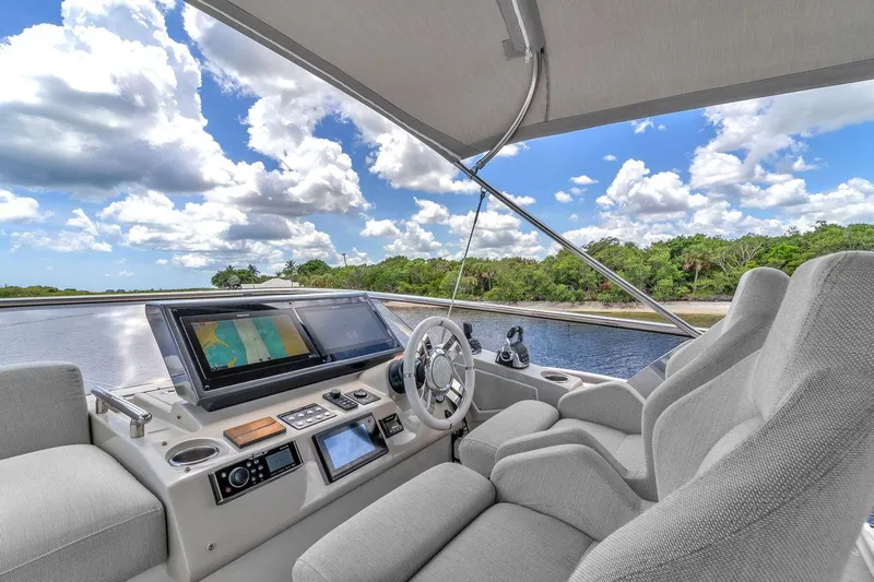 Slide: The Image of Helm of 2020 Azimut S7 FLY yacht with navigation screens, overlooking serene waterway. - 23