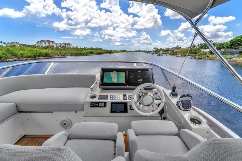 Slide: The Image of 2020 Azimut S7 FLY yacht helm with navigation screens, steering wheel, and river view. - 25