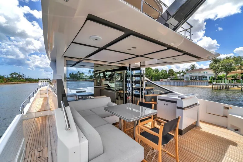 Slide: The Image of Luxurious 2020 Azimut S7 FLY yacht deck with seating, table, and scenic waterfront view. - 35