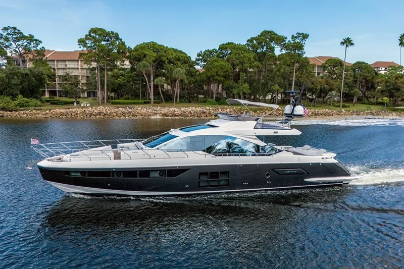 Slide: The Image of Azimut S7 FLY 2020 yacht cruising on a scenic waterway with lush greenery. - 6