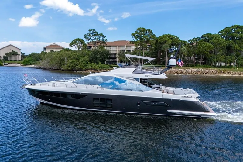Slide: The Image of 2020 Azimut S7 FLY yacht cruising on a scenic waterway with lush greenery. - 7
