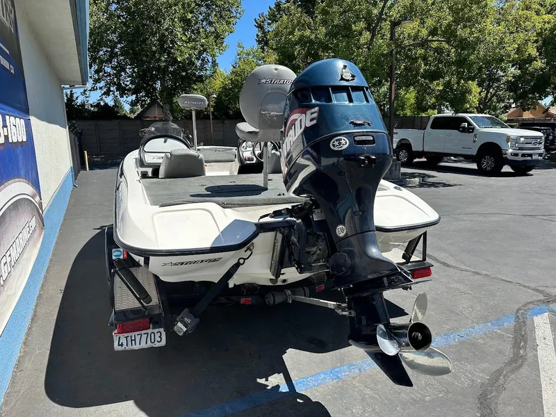 Slide: The Image of 2004 Stratos 285 PRO XL DC boat with Evinrude motor, parked outdoors. - 10