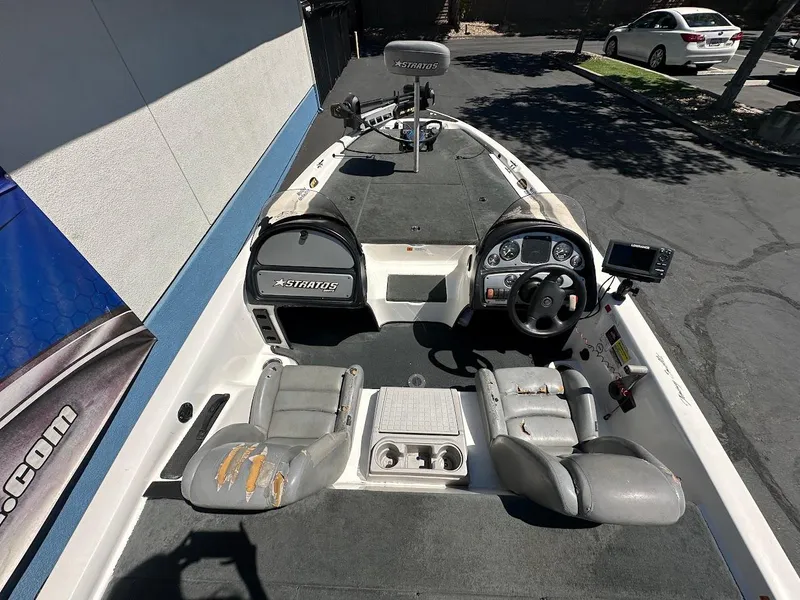 Slide: The Image of 2004 Stratos 285 PRO XL DC boat interior with worn seats and steering console. - 12